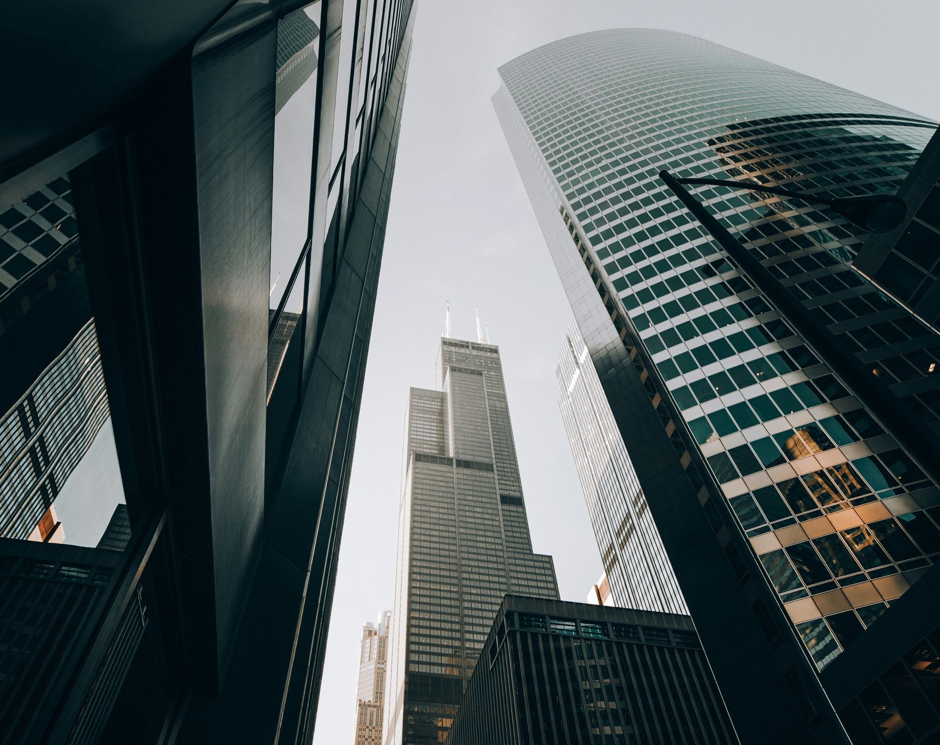 Upward view of modern skyscrapers with reflective glass facades against a clear sky.